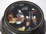 a black box with a painting on it on a white surface