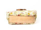 a floral bag with a wooden handle on a white background