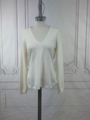 a picture of a white sweater on a mannequin stand