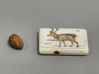 a small box with a picture of a deer and a nut