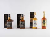 three bottles of whiskey sitting next to each other on a white surface