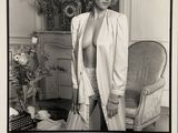 photographie en noir et blanc d'une femme posant dans une pièce où se trouve une chaise