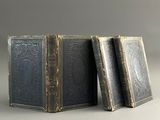 three old books sitting on top of each other on a table