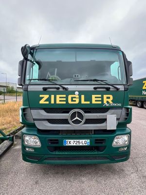 a green truck that is parked on the side of the road