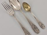 three spoons and a fork sitting on a table