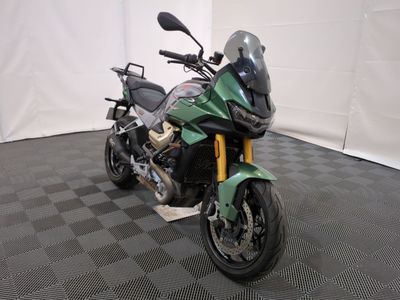 une moto verte garée sur un sol à carreaux noirs et blancs