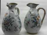 two vases with flowers on them sitting on a table