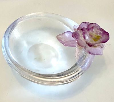 a glass bowl with a flower in it on a table