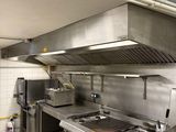 a large commercial kitchen with stainless steel appliances in it