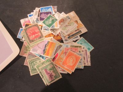 a pile of stamps sitting on a table next to a laptop