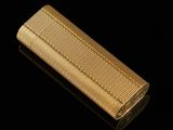 a gold cigarette case sitting on top of a black surface