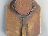 a brass plate with a clock on it on the wall