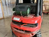 un chariot élévateur rouge garé dans un entrepôt