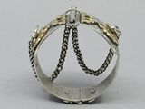 a close up of a silver and gold ring with chains on it