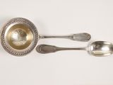 two spoons and a bowl on a white surface