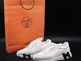 a pair of white sneakers next to a shopping bag