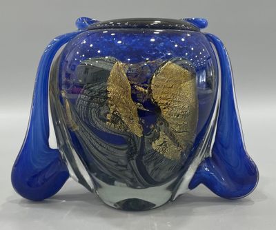 a blue vase with a gold leaf inside of it