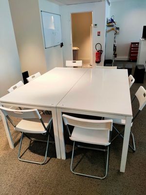 une table blanche avec des chaises et un réfrigérateur blanc en arrière-plan