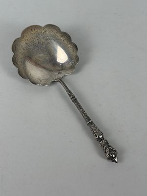 une cuillère en argent ornée d'une fleur, posée sur une table