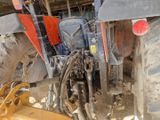 une photo d'un tracteur garé sur un terrain en terre battue