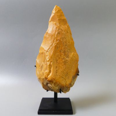 a close up of a piece of food on a stand on a white surface