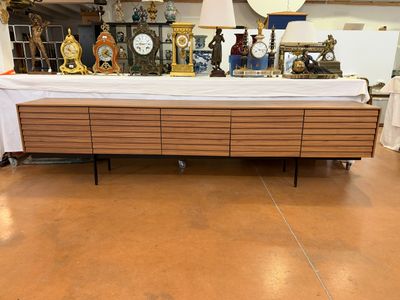 a long table with a bunch of clocks on top of it