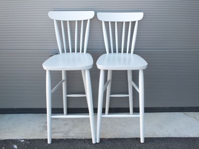 deux chaises blanches placées l'une à côté de l'autre sur le trottoir