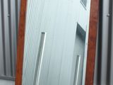 un grand miroir posé par terre à côté d'un bâtiment