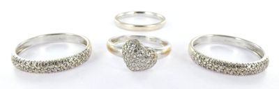 trois bagues en argent sur un fond blanc, avec un diamant au centre