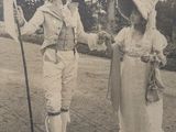 a man and a woman dressed in period clothing holding a flag