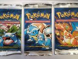three packs of pokemon trading cards on a white surface