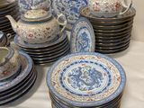 a lot of blue and white plates and cups on a table