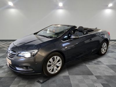 L'Opel grise est garée sur un sol en carrelage à damier.