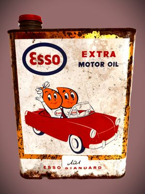 un panneau indiquant « Esso Extra Motor Oil » au bord de la route