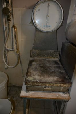 une grande balance dans un coin d'une pièce où se trouvent des toilettes