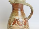 a brown and white pitcher on a white surface
