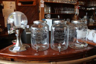 de nombreux bocaux Mason posés sur le bar, remplis de boissons