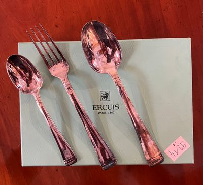 two forks and two spoons sitting on a box on a table