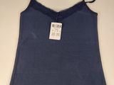 the top of a blue tank top is hanging on a hanger