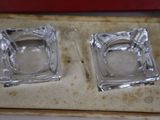 two square glass ashtrays in a box