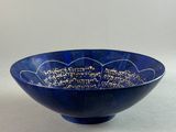 a close up of a blue bowl with writing on it