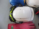a white hard hat and a pair of gloves on the floor