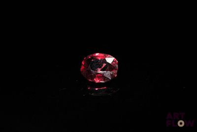 a close up of a red diamond on a black surface
