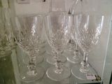 plusieurs verres à vin vides posés sur une étagère en verre dans une vitrine