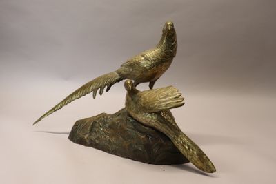 a bronze statue of two birds sitting on a rock