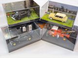 trois modèles de voitures différents exposés dans des vitrines posées sur une table