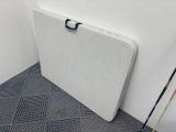 a white table with a black handle in a room