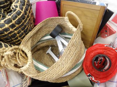 un panier avec une corde et quelques autres objets posés sur un lit