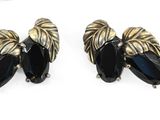 deux paires de boucles d'oreilles noires et dorées posées sur un fond blanc