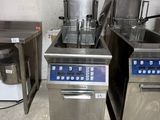 two deep fryers in the middle of a kitchen